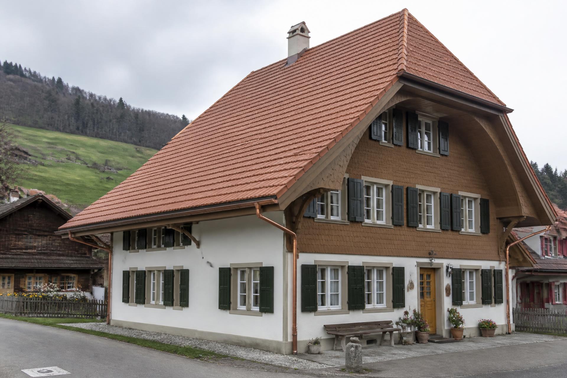 Bauernhaus mit steilem, neu eingedecktem Ziegeldach und Holzfassade